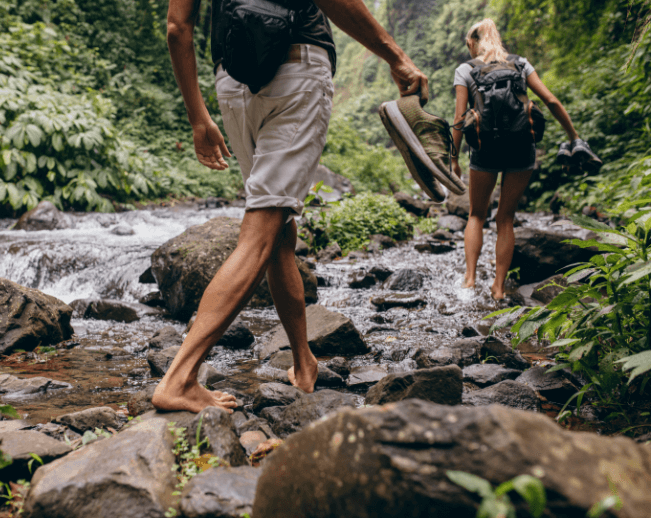 couple-crossing-the-stream-barefooted-PWG74QY